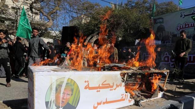 Palestinian Hamas supporters burn a model of a coffin representing the U.S. embassy in Jerusalem with a picture of U.S. President Donald Trump, during a rally in Gaza