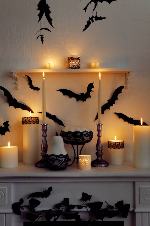 Halloween composition on fireplace on white wall background