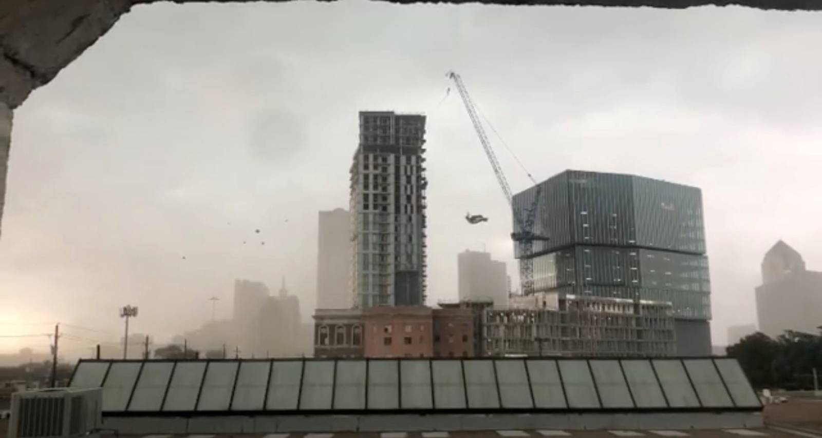 A construction crane sways before toppling amidst high winds in Dallas, Texas