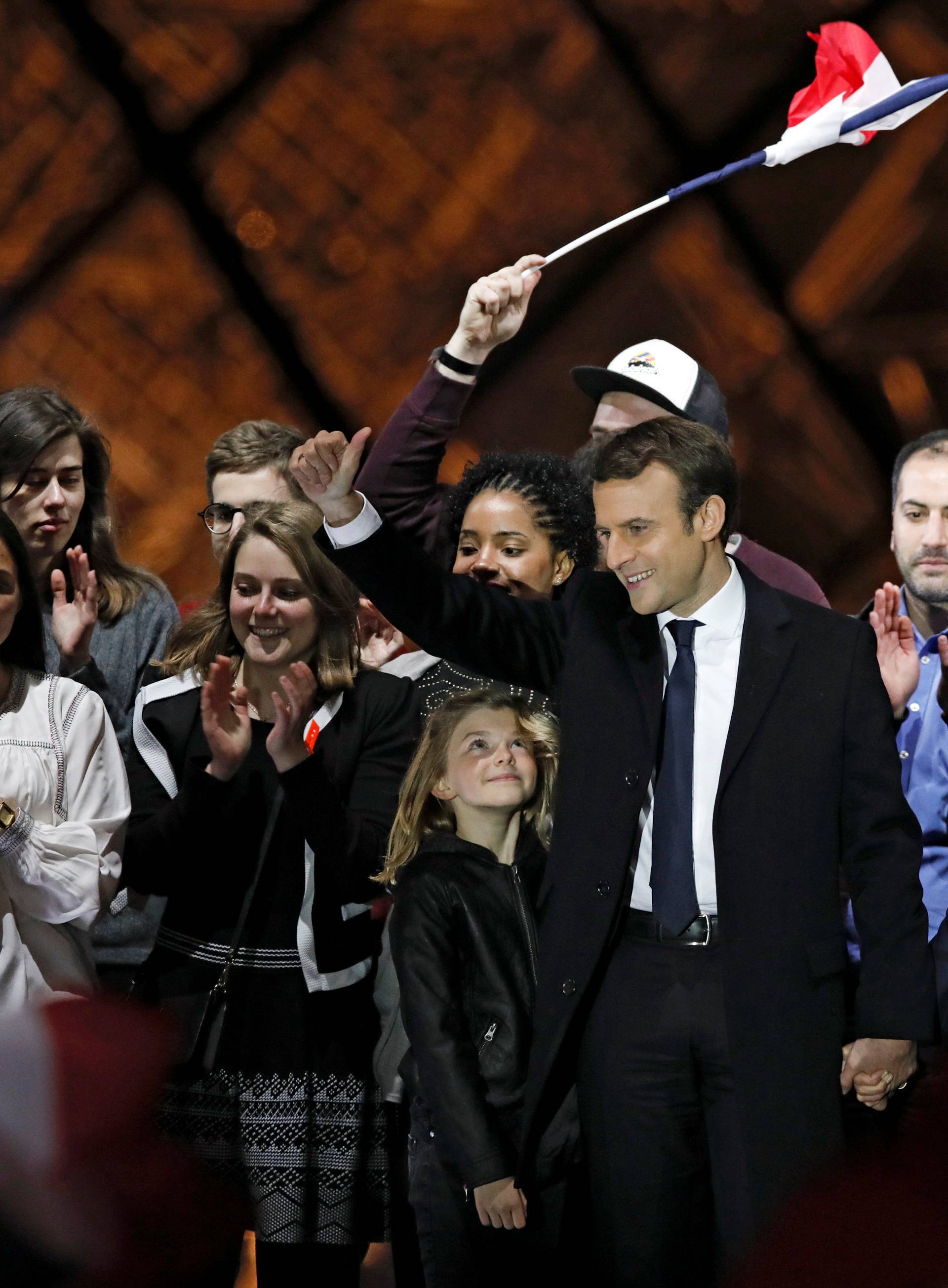 French President elect Emmanuel Macron and his wife Brigitte Trogneux celebrate on the stage at his victory rally near the Louvre in Paris