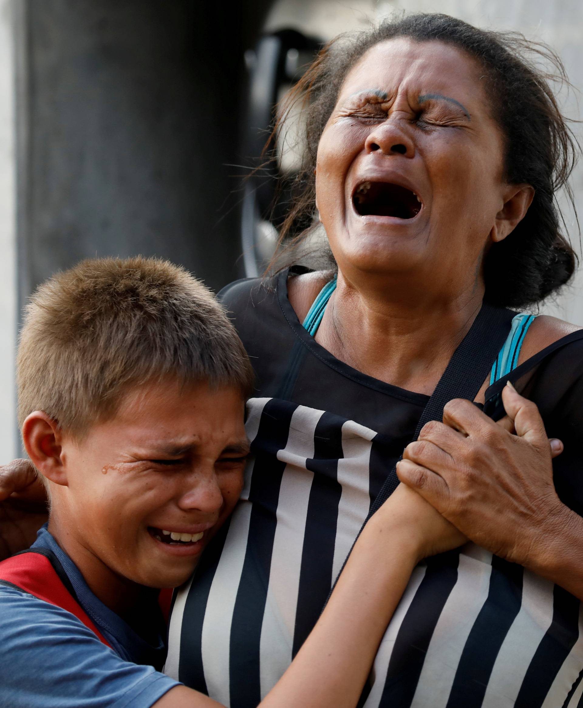 Relatives of inmates held at the General Command of the Carabobo Police react as they wait outside the prison where a fire occurred in the cells area in Valencia