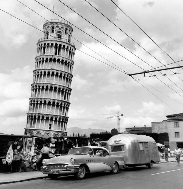 Buick pulling an Airstream Trailer in Pisa, Italy as part of a Wally Byam 1956 European Caravan.