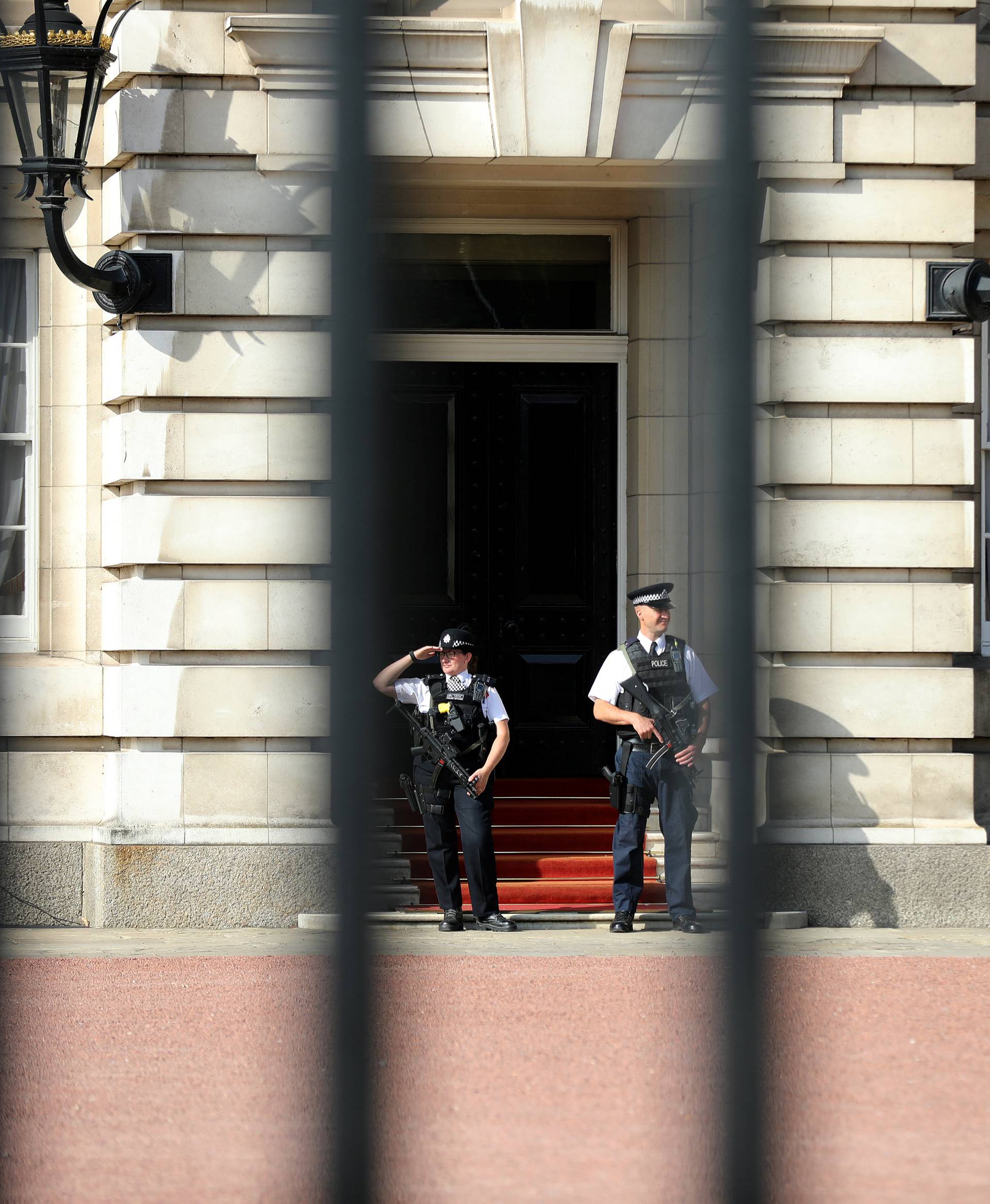 Police officers are seen on duty within the grounds of Buckingham Palace in London