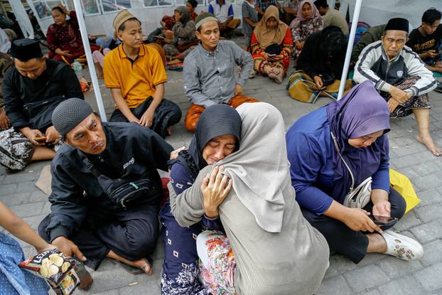 A relative of a victim of a collapsed building reacts in Sidoarjo