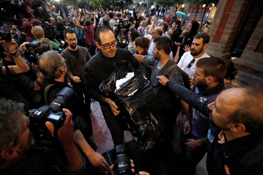 A  man holds ballots at a polling station for the banned independence referendum in Barcelona