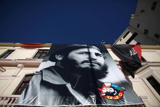 A man hangs a photograph of Cuba
