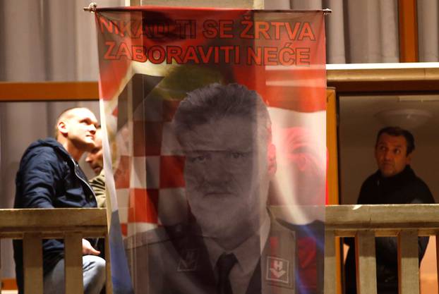 Bosnian Croats hang a flag displaying a portrait of General Slobodan Praljak in Mostar