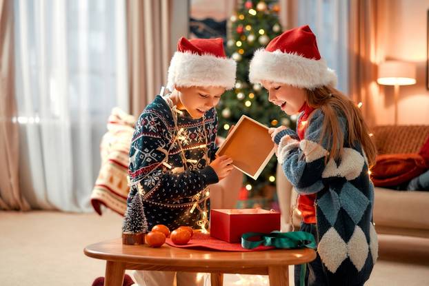 Cheerful,Happy,Children,In,Santa,Claus,Hats,Open,A,Gift.