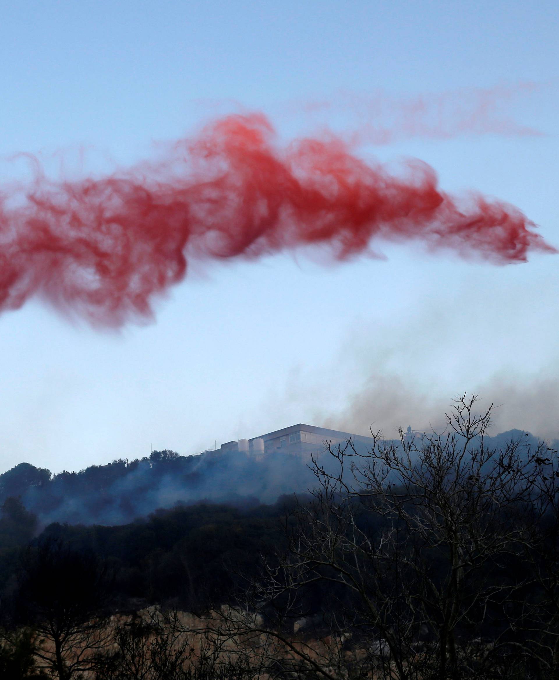 Fire-retardant material is seen mid-air after it was dropped by aerial firefighting squadrons during a wildfire in the northern city of Haifa, Israel 