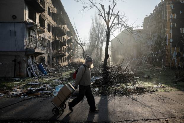 A resident walks near apartment buildings damaged by a Russian military strike in the frontline town of Kostiantynivka