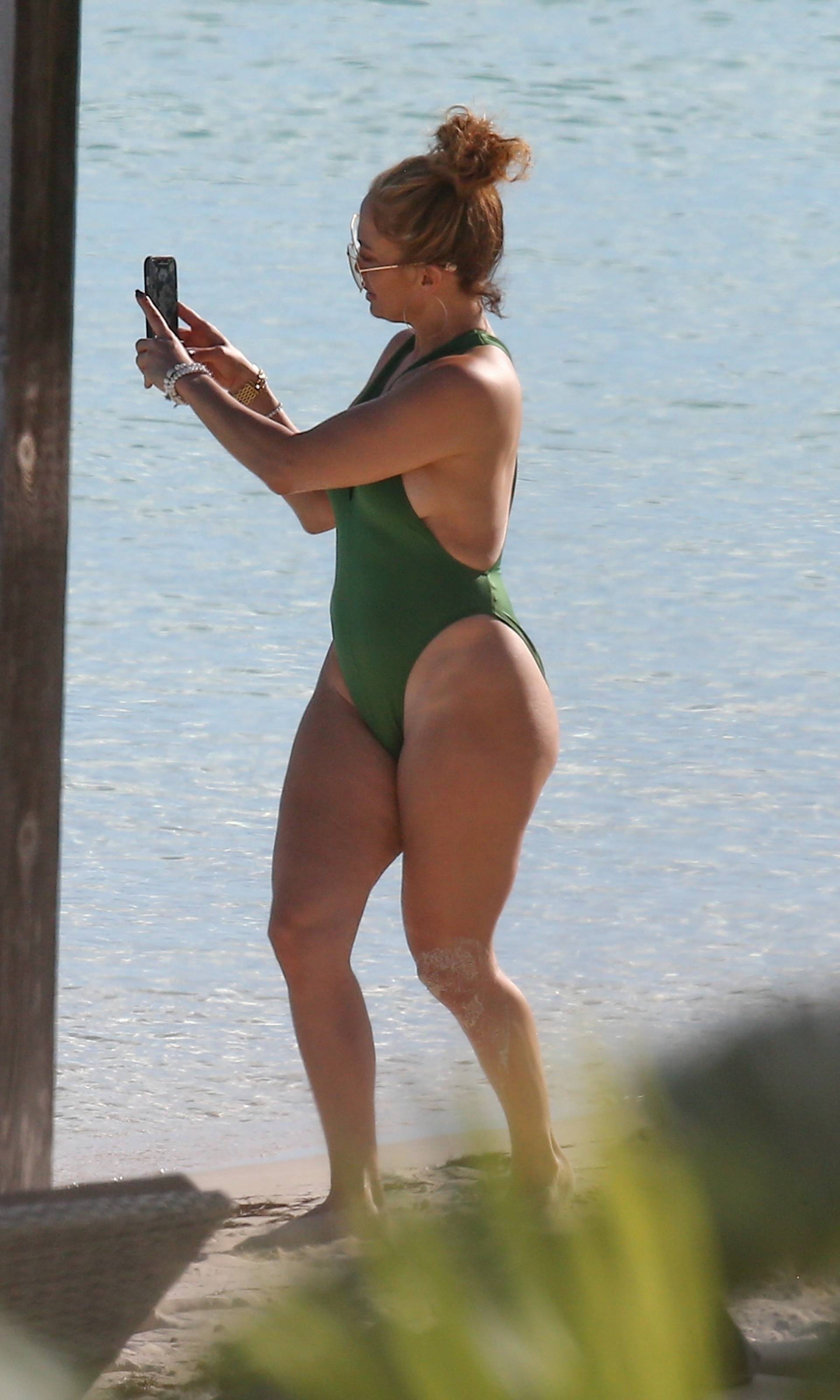 *PREMIUM-EXCLUSIVE* Jennifer Lopez is pictured in plunging green swimsuit as she soaks in the sun in Turks and Caicos **Web Embargo until 1 pm PST on January 15, 2021**