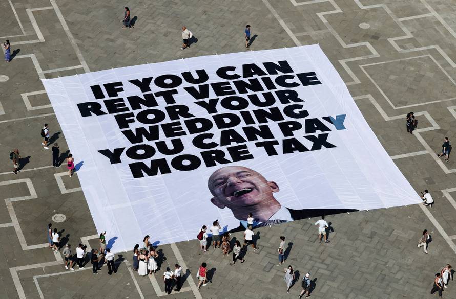 A large banner against Amazon founder Jeff Bezos lies on the ground in St. Mark's Square