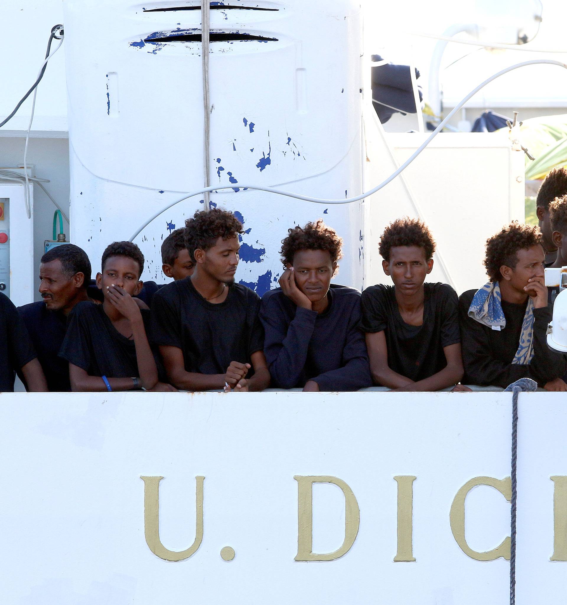 Migrants wait to disembark from the Italian coast guard vessel "Diciotti" at the port of Catania