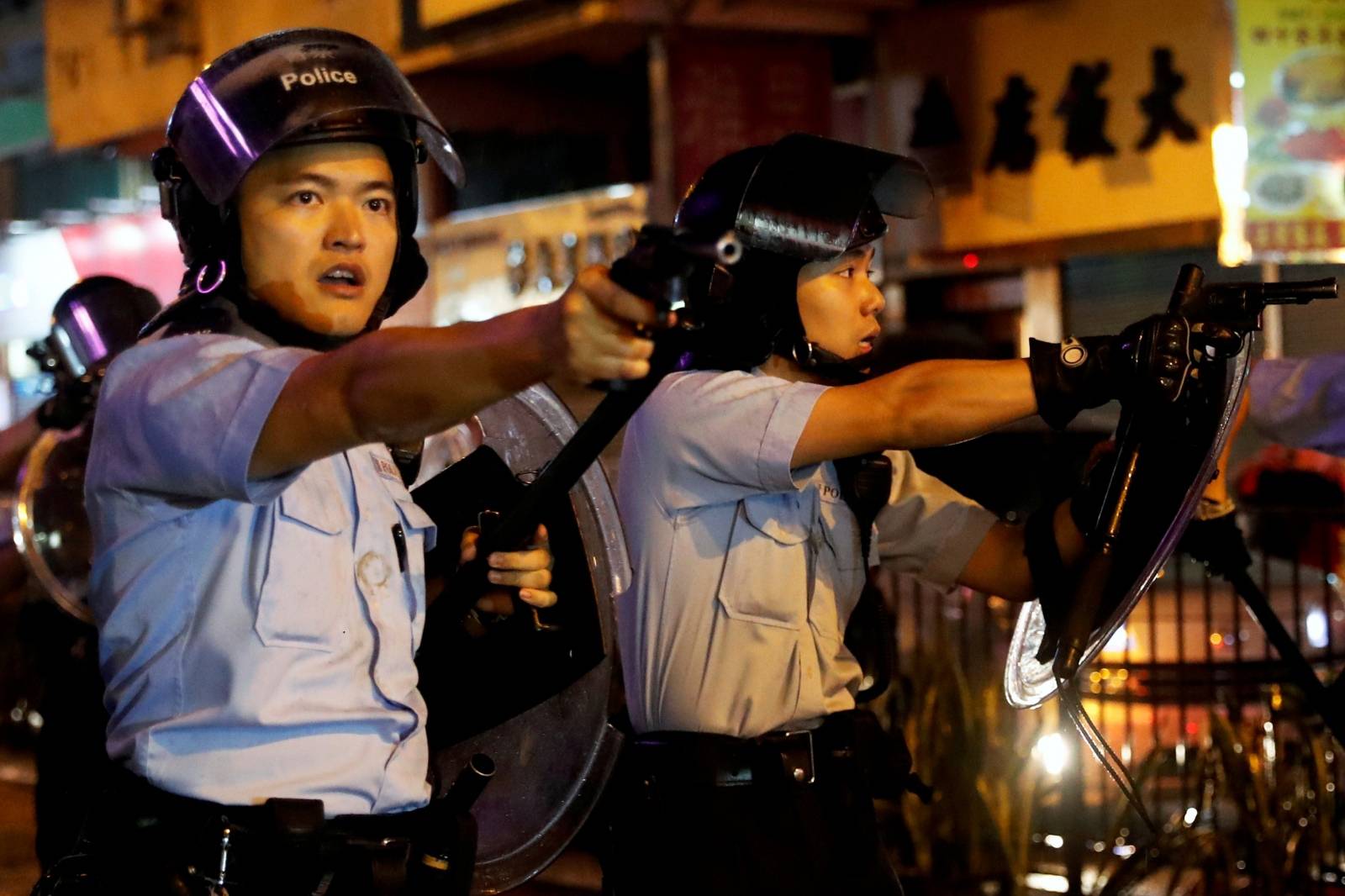 Police officers point their guns towards anti-extradition bill protesters after a clash, at Tsuen Wan, in Hong Kong