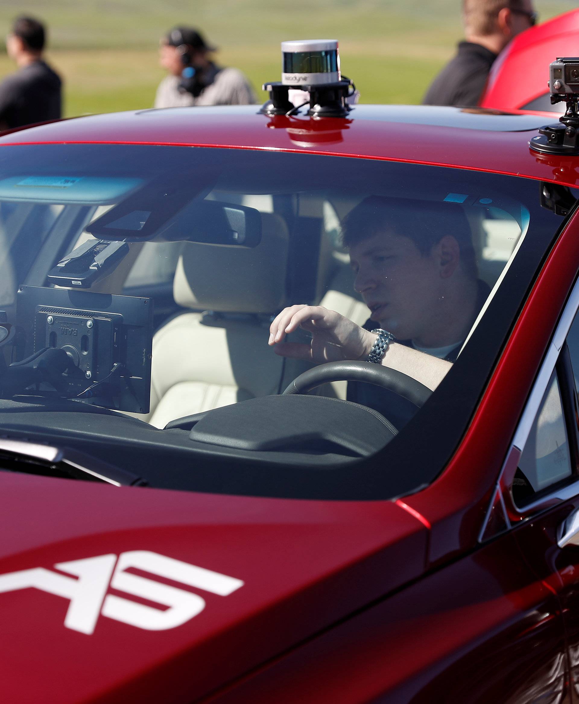 An engineer works on an AutonomouStuff Automated Research Development Vehicle during a self-racing cars event at Thunderhill Raceway in Willows, California