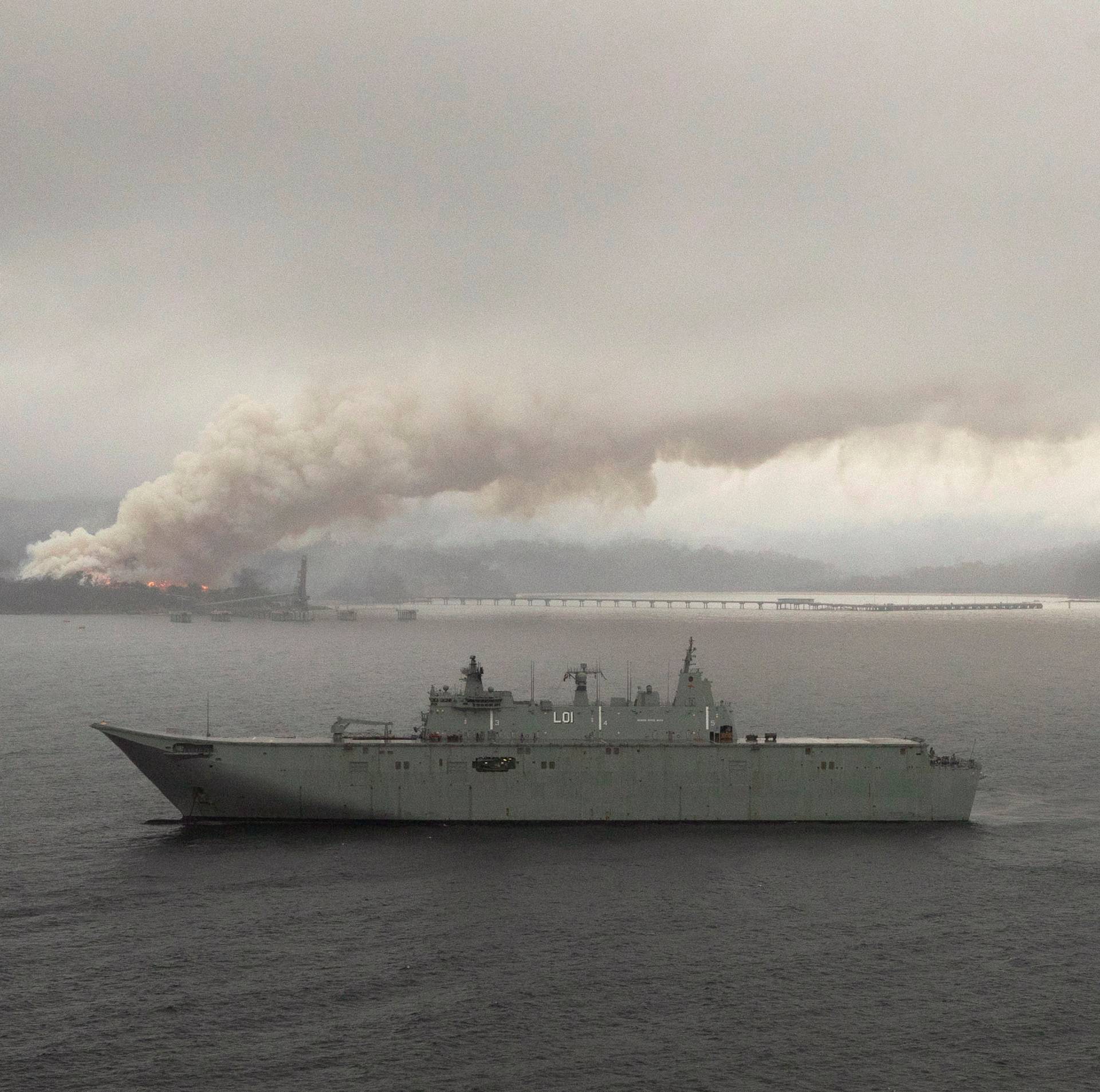 HMAS Adelaide operates off the coast of Eden, Australia, as fires burn during Operation Bushfire Assist