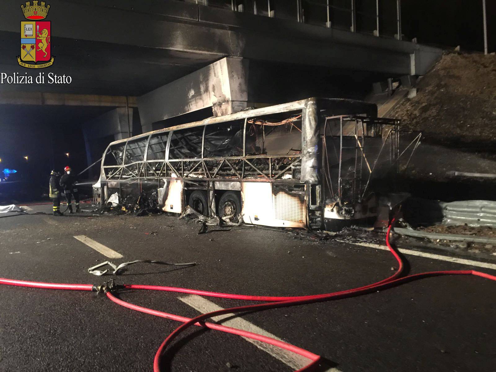 A charred bus, which was carrying Hungarian students, is seen on a side of a highway, near Verona