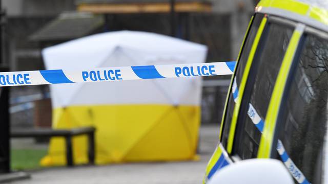 A police car is parked next to crime scene tape, as a tent covers a park bench on which former Russian inteligence officer Sergei Skripal, and a woman were found unconscious after they had been exposed to an unknown substance, in Salisbury