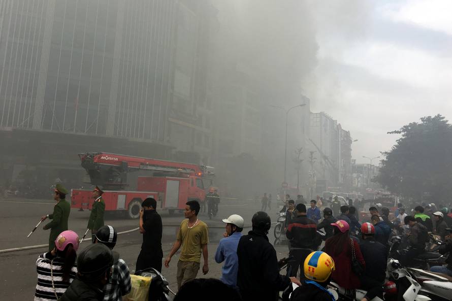 Firefighters work after a fire broke out at a karaoke lounge in Hanoi