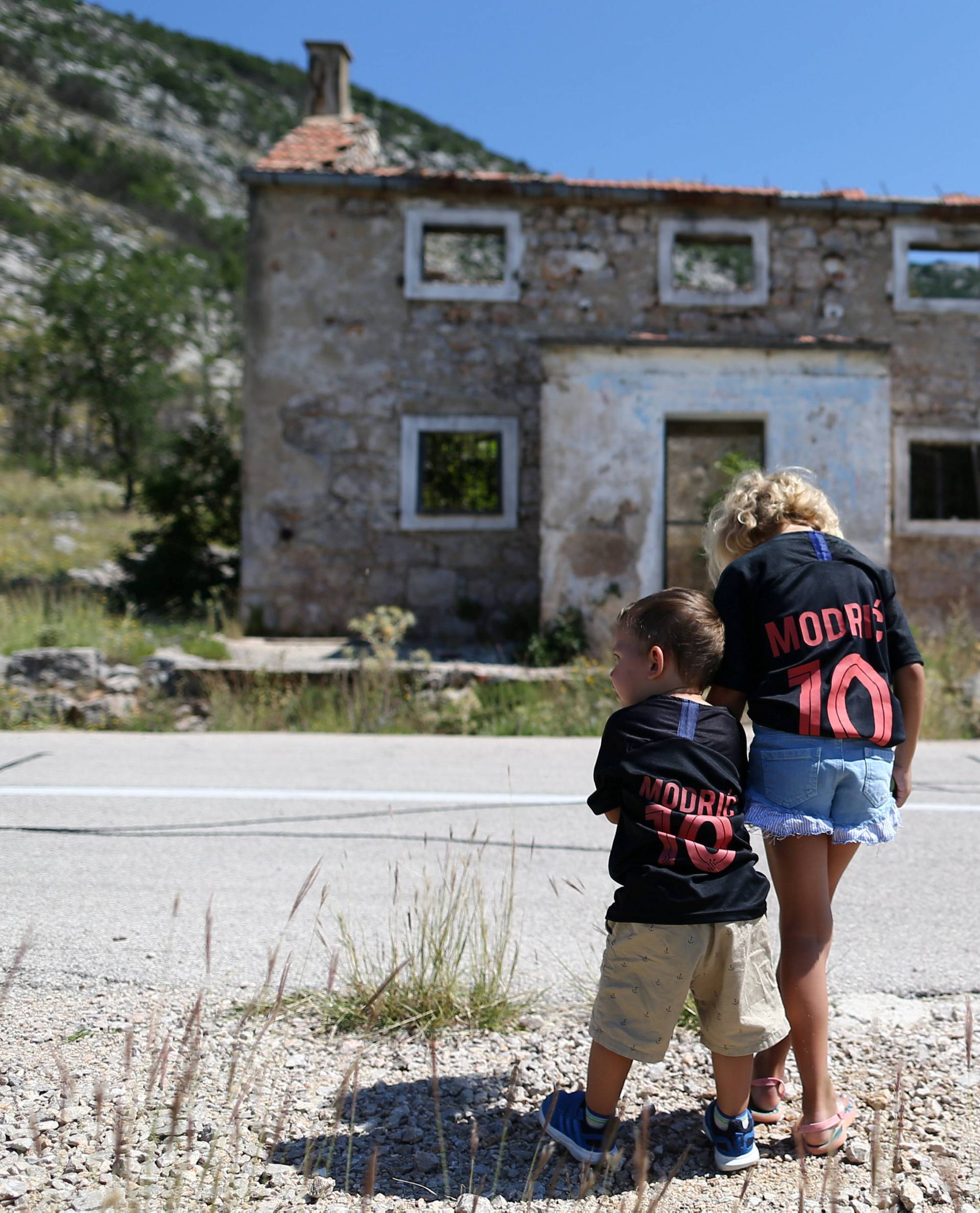 Kids are seen in front of Luka Modric's birth house in Modrici village