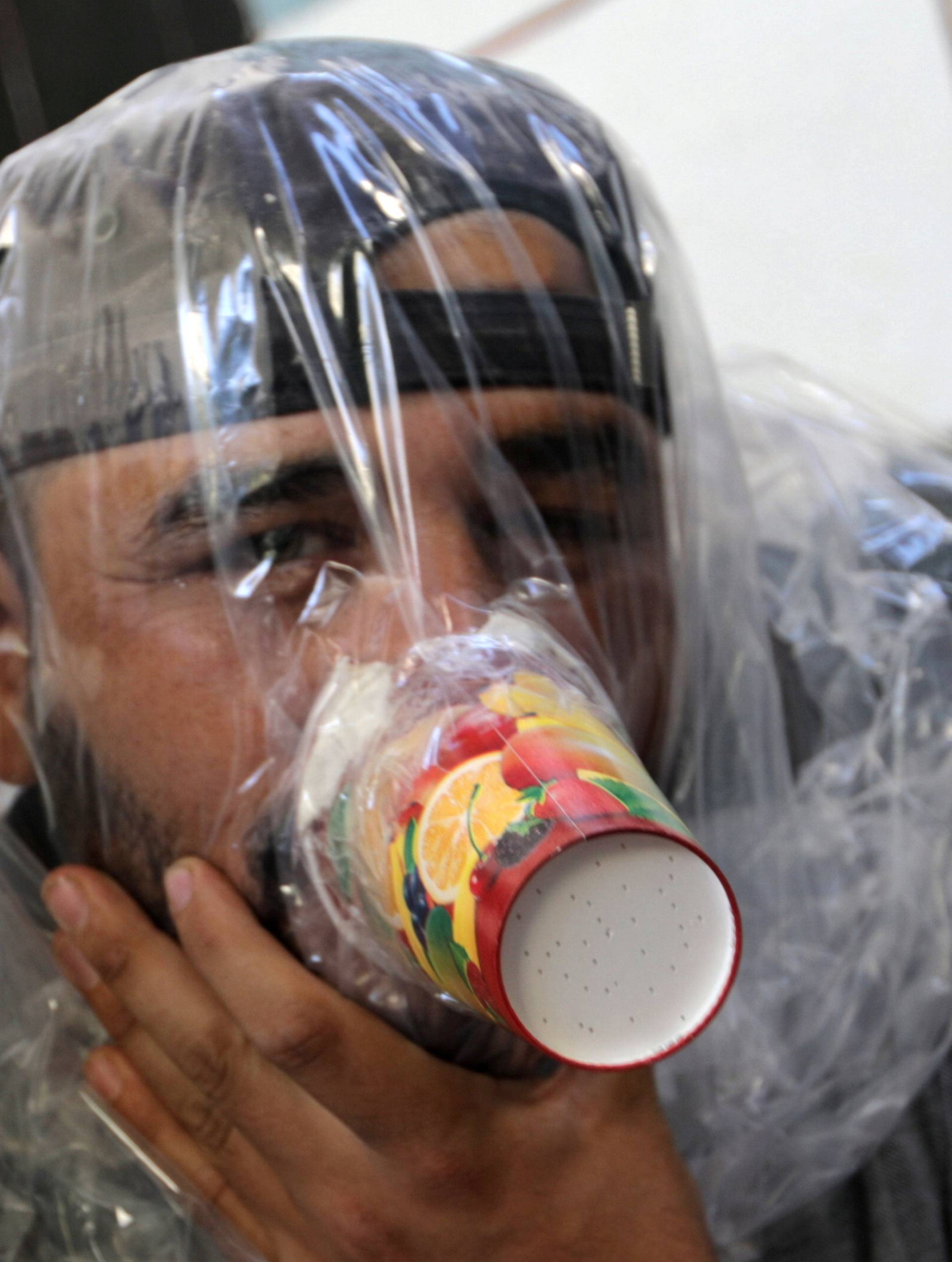 Hudhayfa al-Shahad tries an improvised gas mask in Idlib