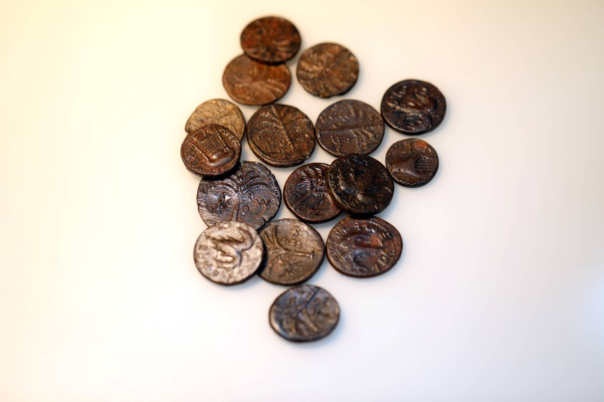 Ancient coins, part of various artefacts recently discovered in the Judean Desert caves along with scroll fragments of an ancient biblical texts, are seen during an unveiling event for media at Israel Antiquities Authority laboratories in Jerusalem