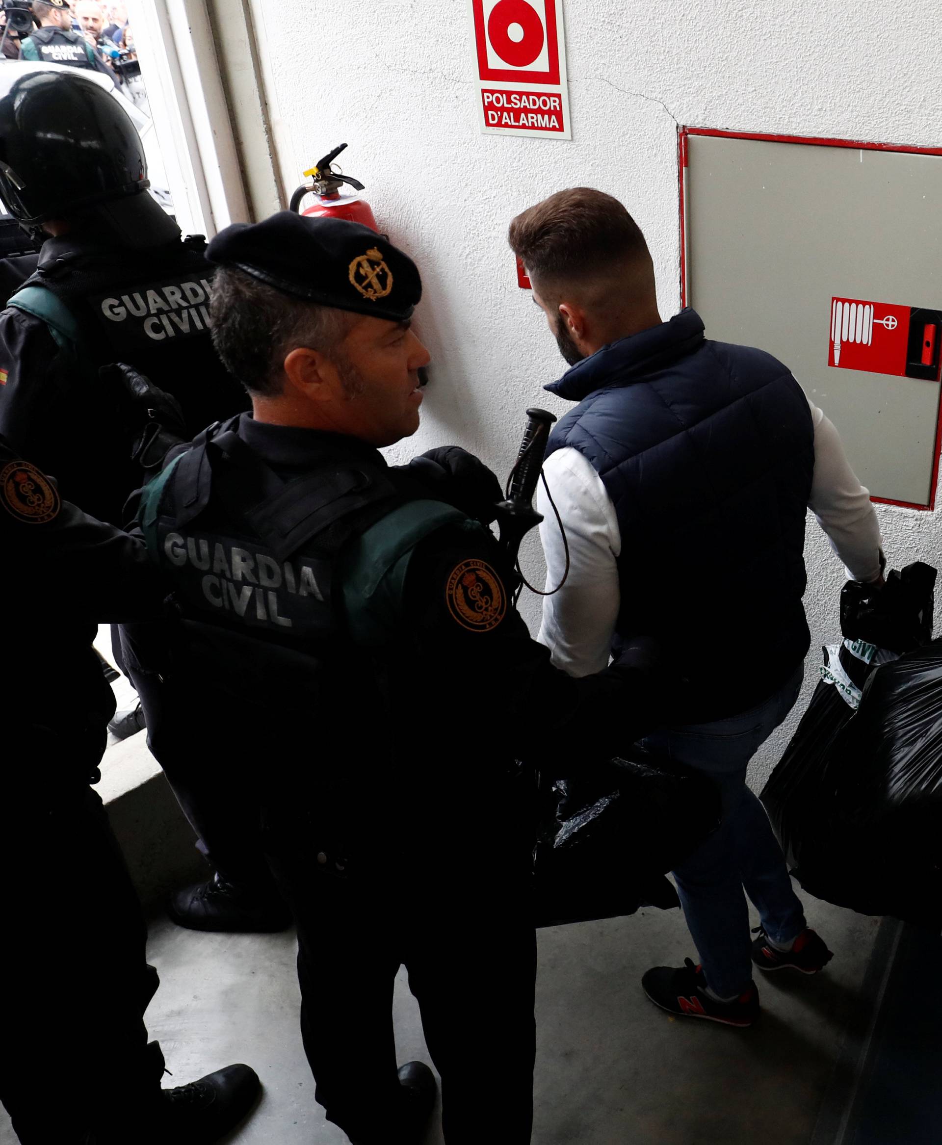 Spanish Civil Guard officers carry confiscated electoral material as they walk out from a polling station for the banned independence referendum where Catalan President Carles Puigdemont was supposed to vote in Sant Julia de Ramis