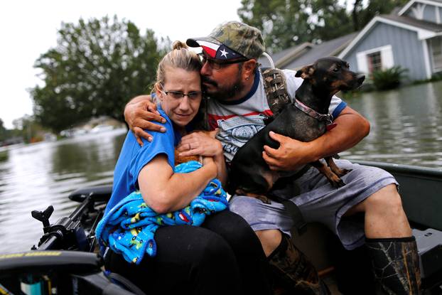 David Gonzalez comforts his wife Kathy after being rescued from their home flooded by Tropical Storm Harvey in Orange, Texas