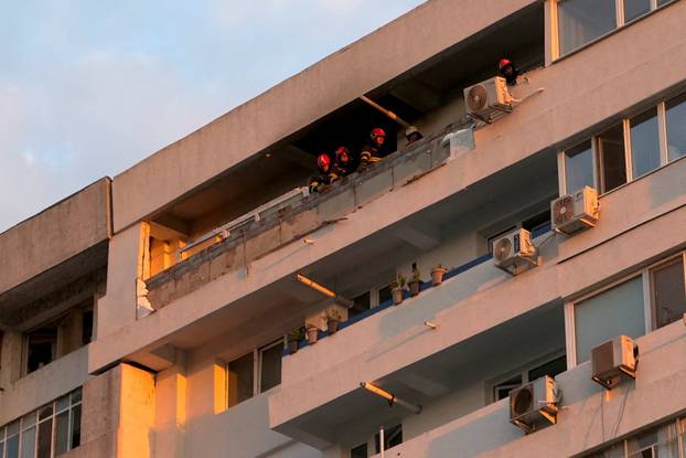 Firefighters and law enforcement work on the site of a explosion at a residential block of flats following a drone hit close to the border with Ukraine