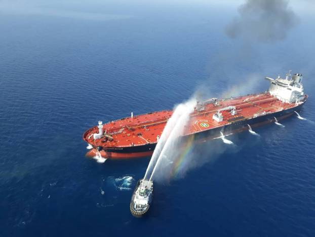 An Iranian navy boat tries to stop the fire of an oil tanker after it was attacked in the Gulf of Oman