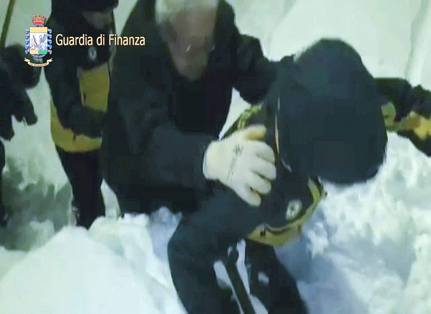 A photo taken from a video shows a survivor, helped by rescuers, coming out from Hotel Rigopiano in Farindola, central Italy, hit by an avalanche