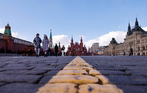 People walk in the Red Square on a sunny day in Moscow