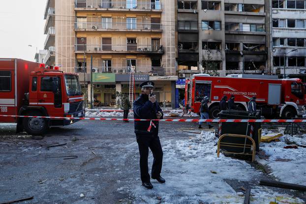 A police officer blocks the road after a blast in Athens