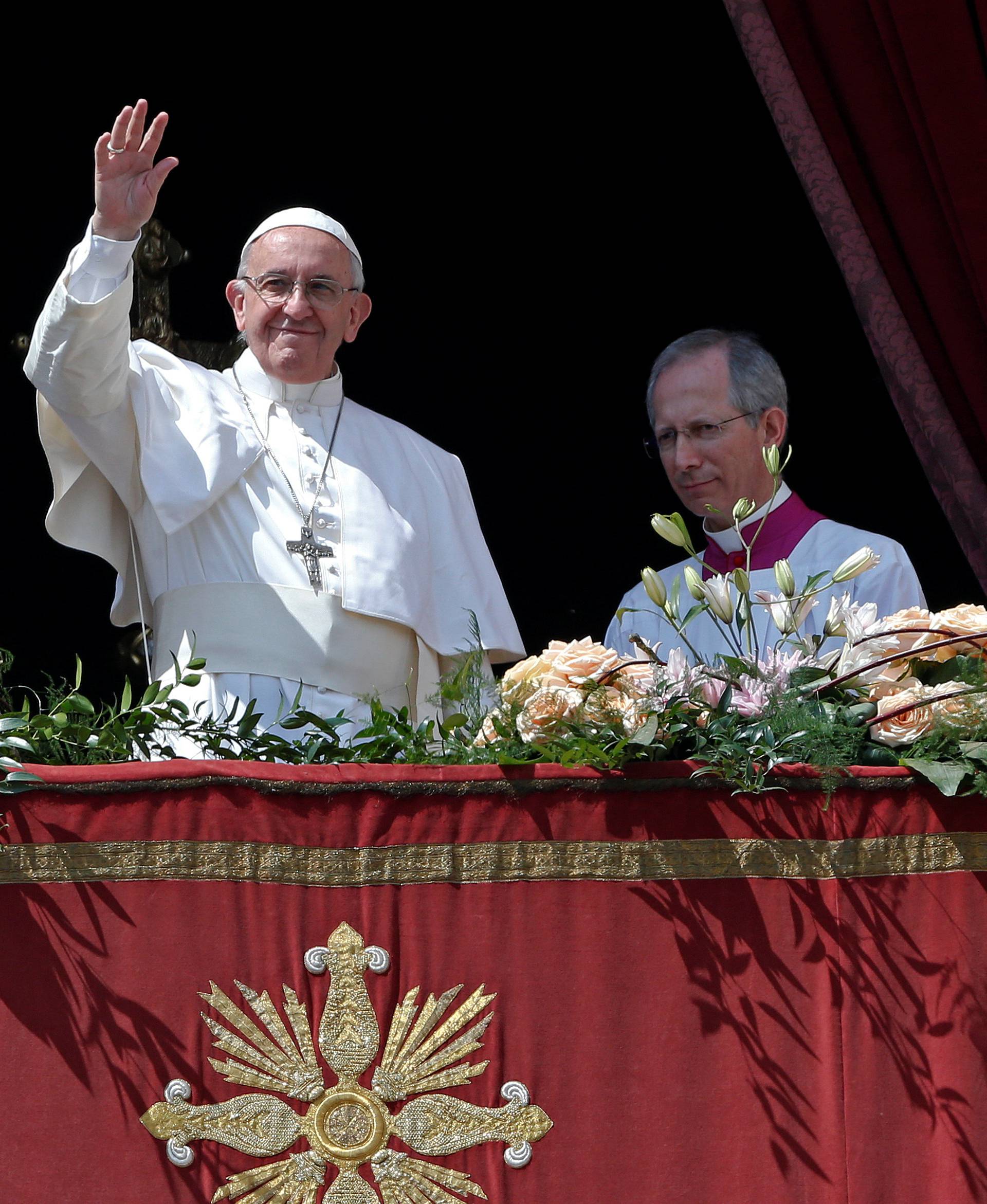 Pope Francis waves at the end of his "Urbi et Orbi" (to the city and the world) message from the balcony overlooking St. Peter's Square at the Vatican