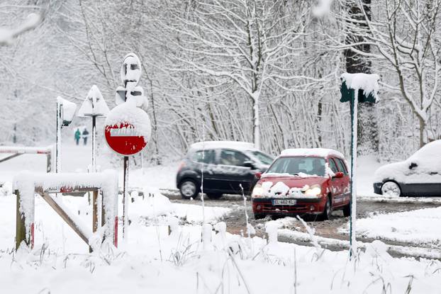 Commuters drive in the snow-covered Bois de Vincennes in Paris, France, as winter weather with snow and freezing temperatures arrive in France