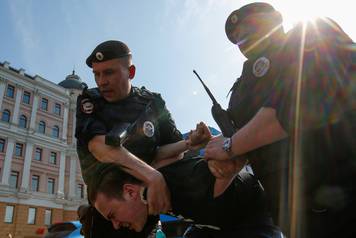 Policemen detain an opposition supporter during a protest ahead of President Vladimir Putin's inauguration ceremony, Moscow