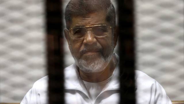 FILE PHOTO -  Ousted Egyptian President Mursi is seen behind bars during his trial at a court in Cairo