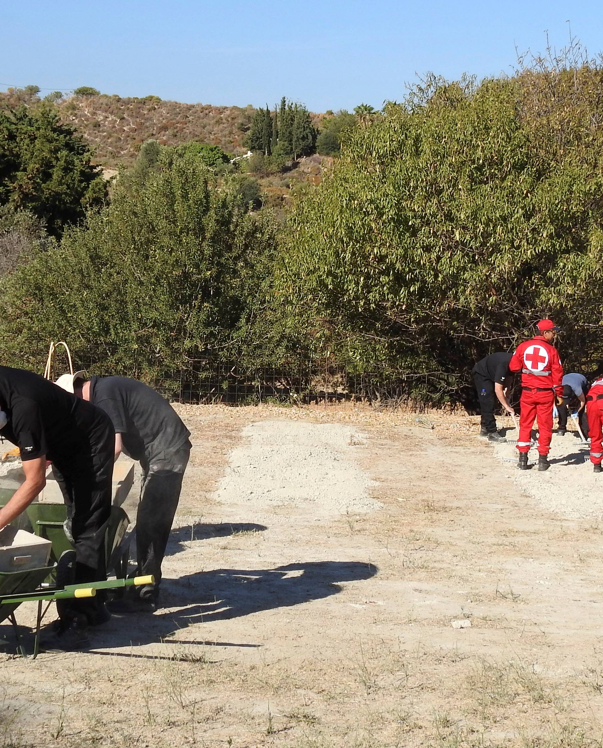 South Yorkshire police officers and members of the Greek rescue service investigate the ground while excavating a site during an investigation for Ben Needham on the island of Kos