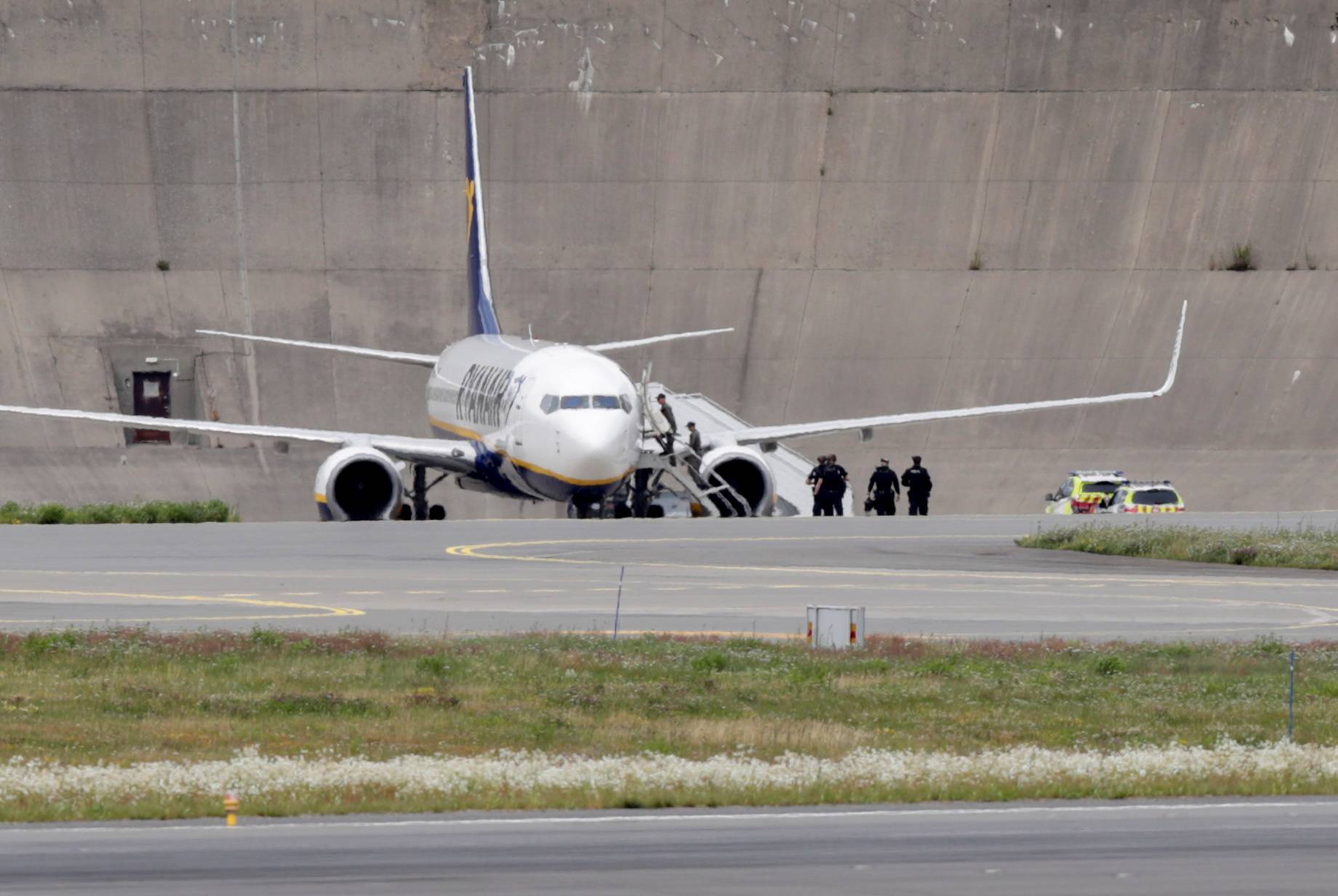 Police officers are seen near a Ryanair plane after it received a bomb threat in Oslo