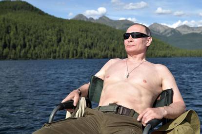 FILE PHOTO: Russian President Vladimir Putin relaxes after fishing during the hunting and fishing trip which took place on August 1-3 in the republic of Tyva in southern Siberia