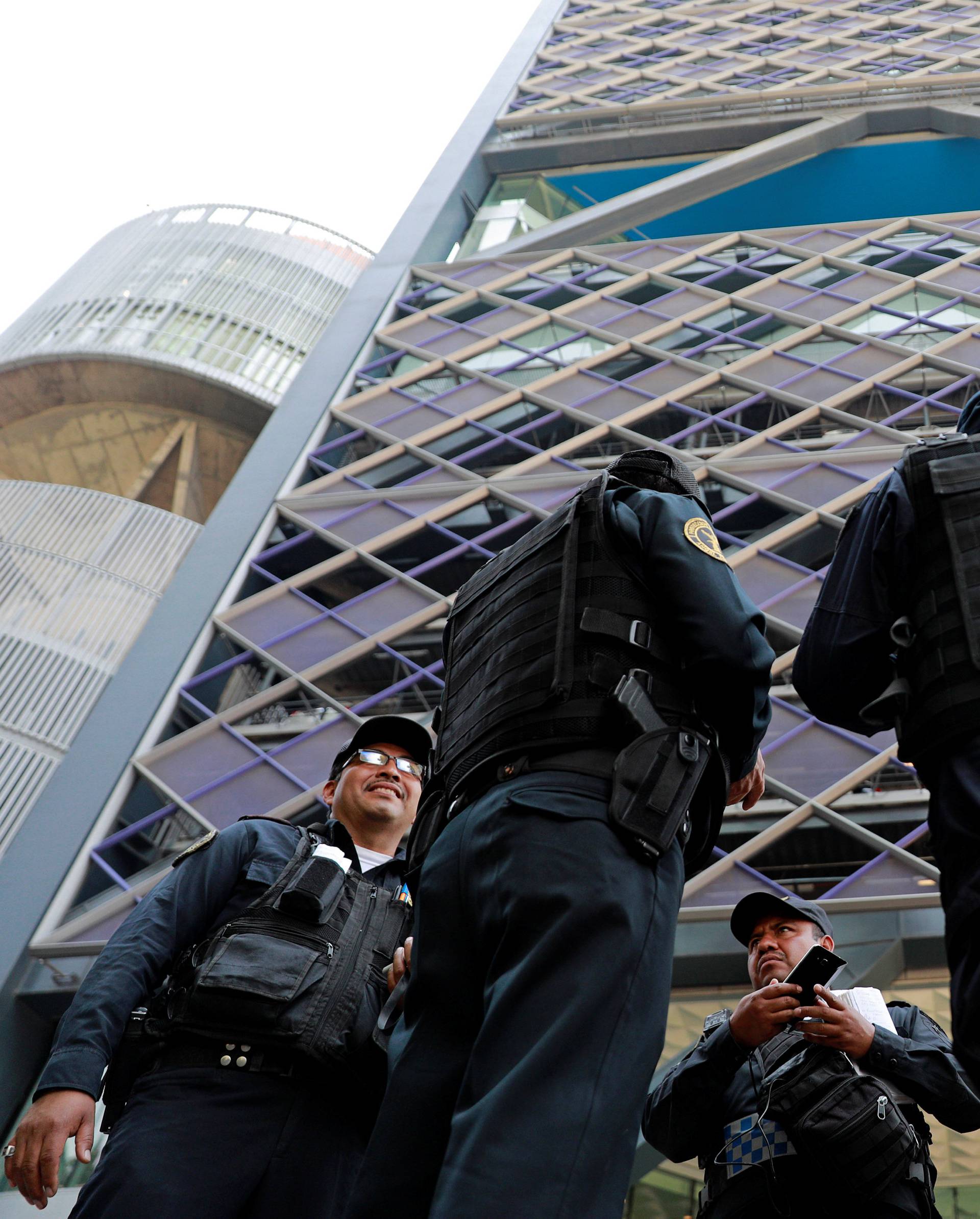 Police officers stand guard outside the tower after people were evacuated from the Mexican headquarters of Spain's BBVA, in Mexico City