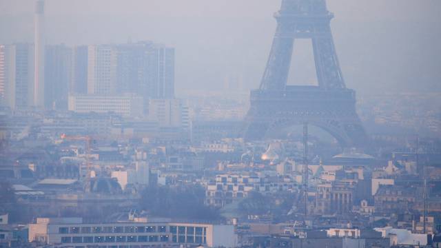 FILE PHOTO: The Eiffel Tower is surrounded by a small-particle haze which hangs above the skyline in Paris