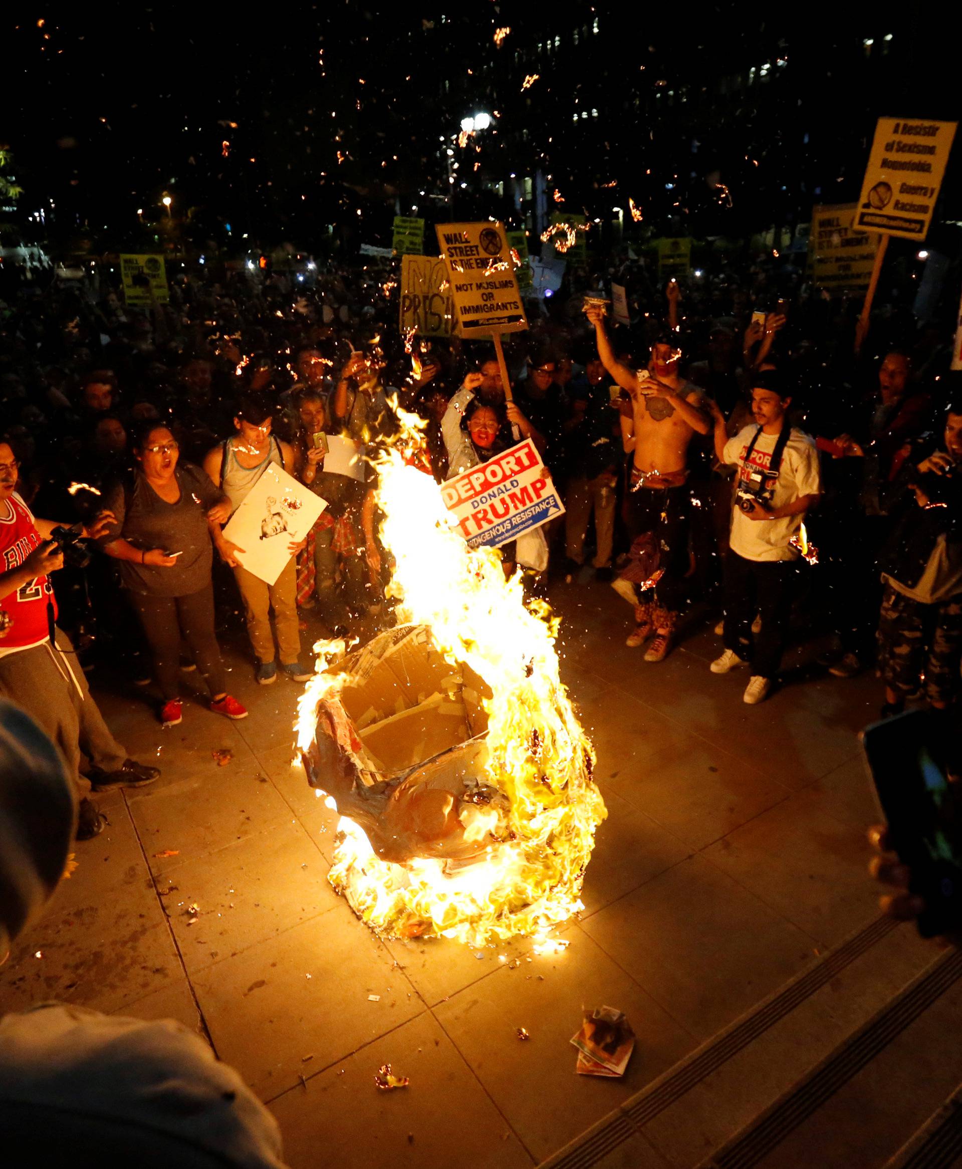 A Donald Trump pinata is burned by people protesting the election of Republican Donald Trump as the president of the United States in downtown Los Angeles
