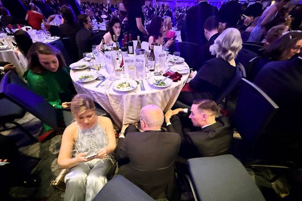 Guests watch from tables after U.S. President Donald Trump and first lady Melania Trump were rushed out of the White House Correspondents' Association dinner