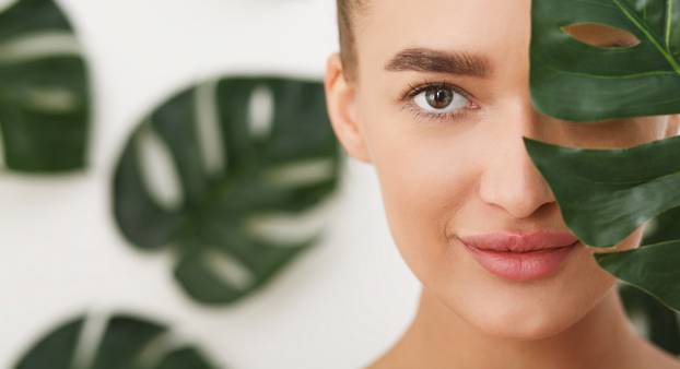 Woman with natural make up and green leaf