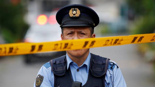 A police officer stands guard near a facility for the disabled, where a deadly attack by a knife-wielding man took place, in Sagamihara, Kanagawa prefecture, Japan