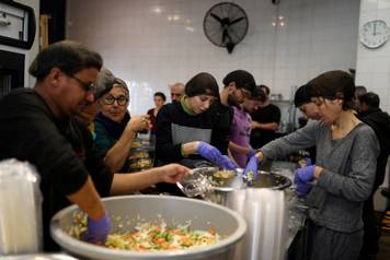 Volunteers prepare meals for displaced people and refugees following an escalation between Hezbollah and Israel amid the U.S.-Israeli conflict with Iran, in Beirut