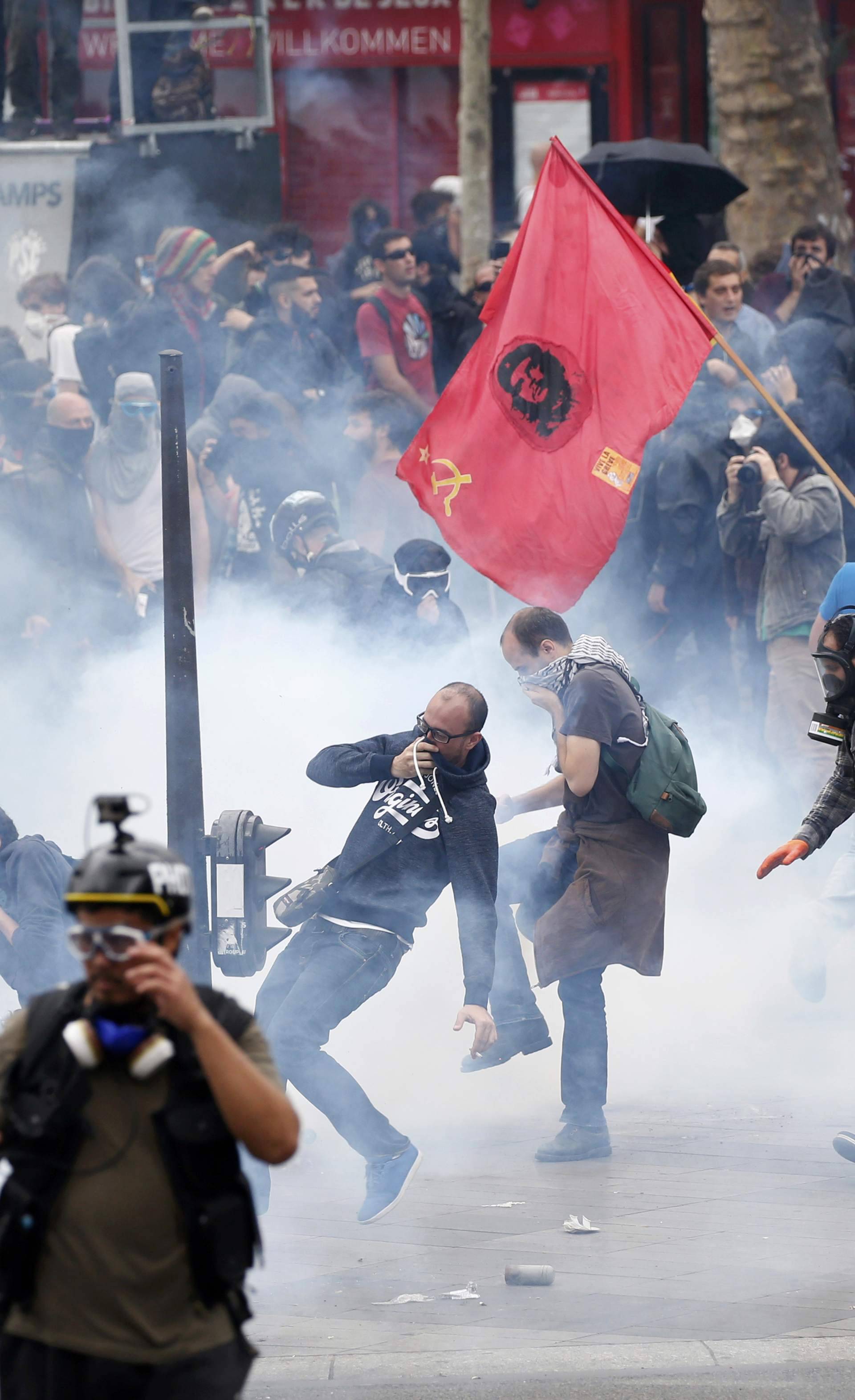 Tear gas fills the air as demonstrators clash with French riot police during a march near the Place de la Republique square in Paris