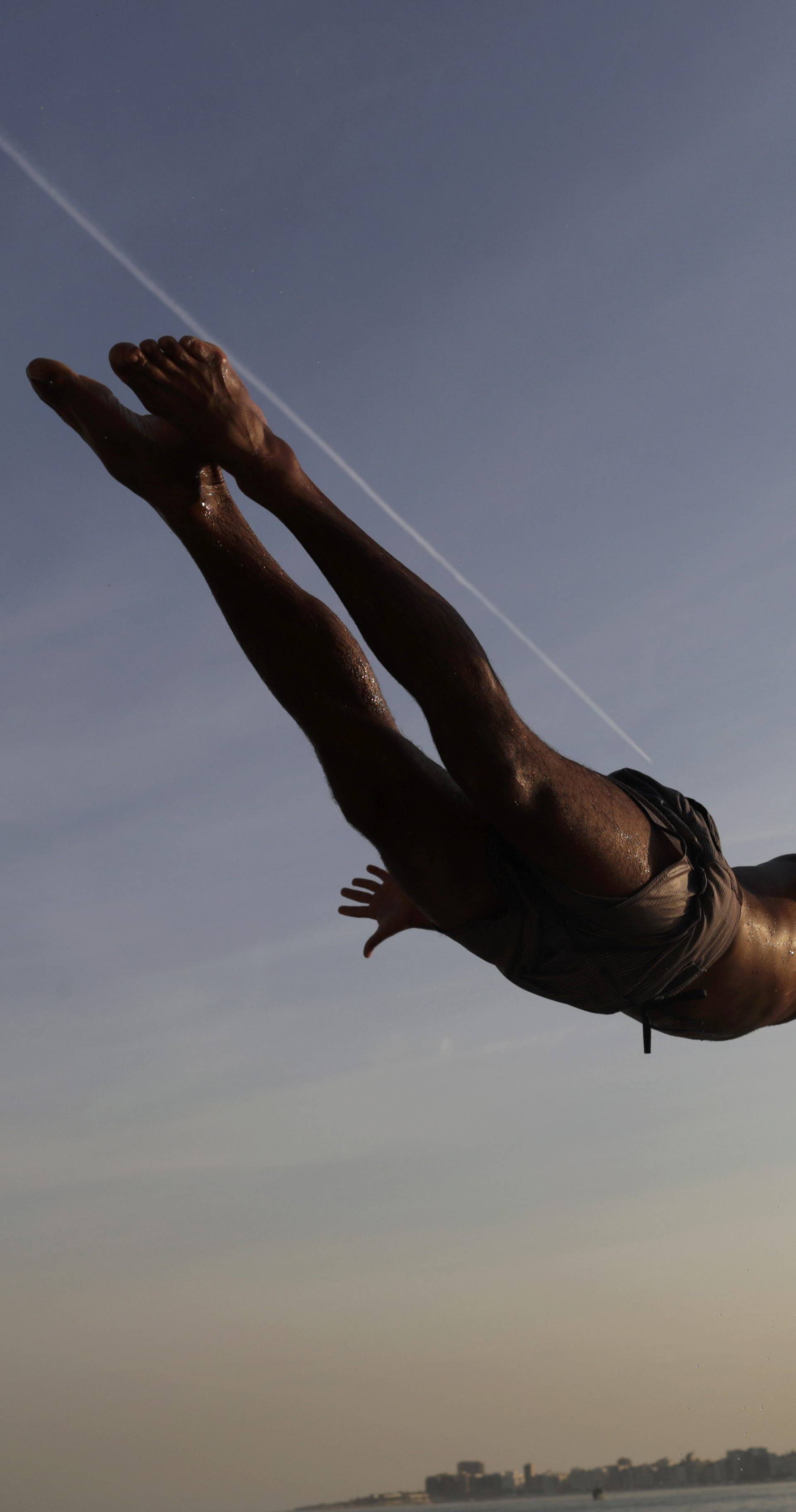 A bather dives into the sea along Leme Beach in Rio de Janeiro