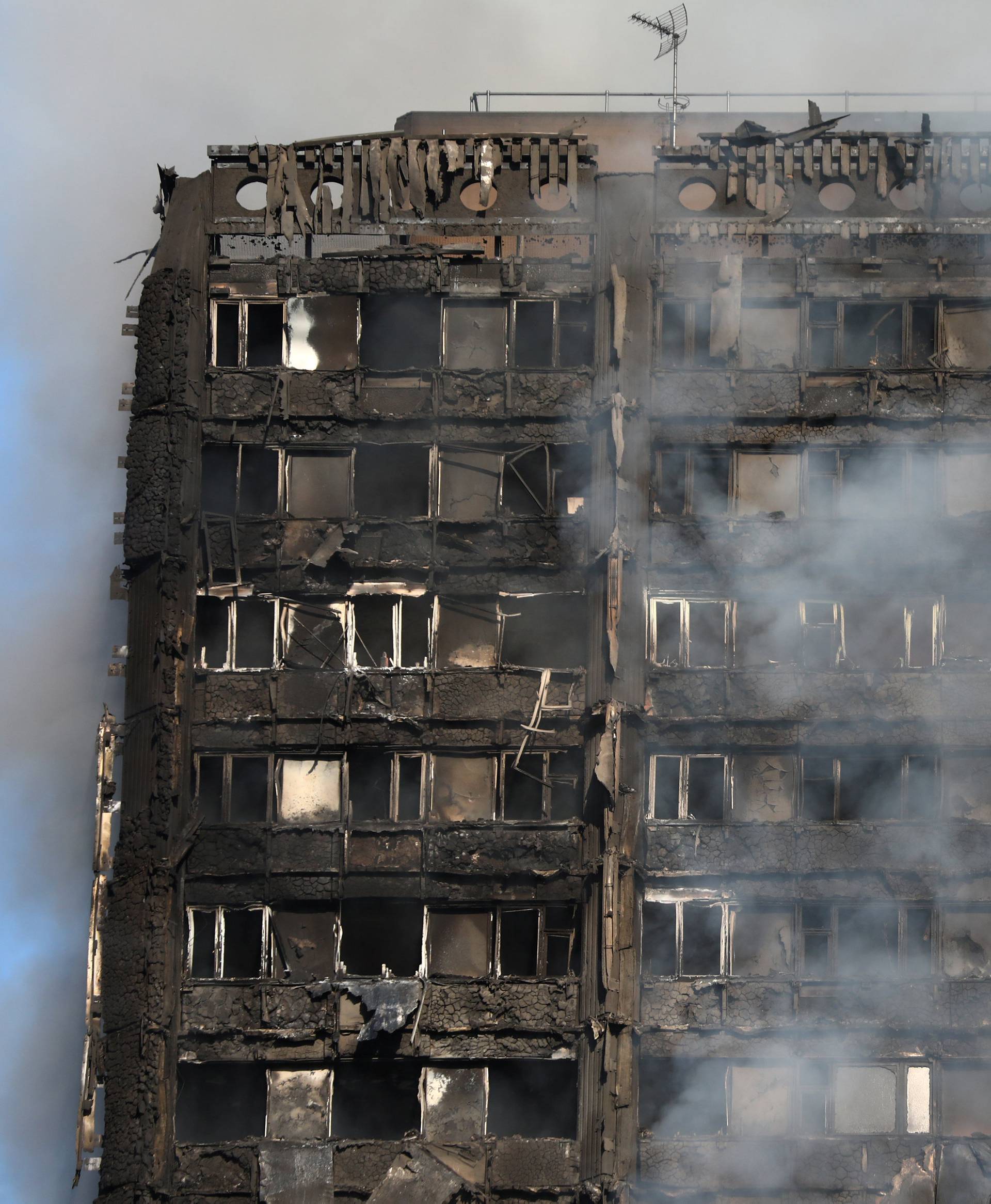 Smoke billows from a tower block severly damaged by a serious fire, in north Kensington, West London